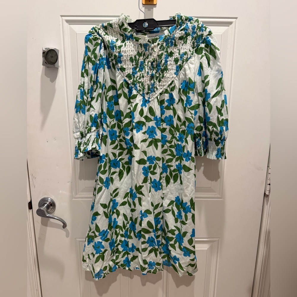 Olivia James dress features a smocked bodice and blue floral print.